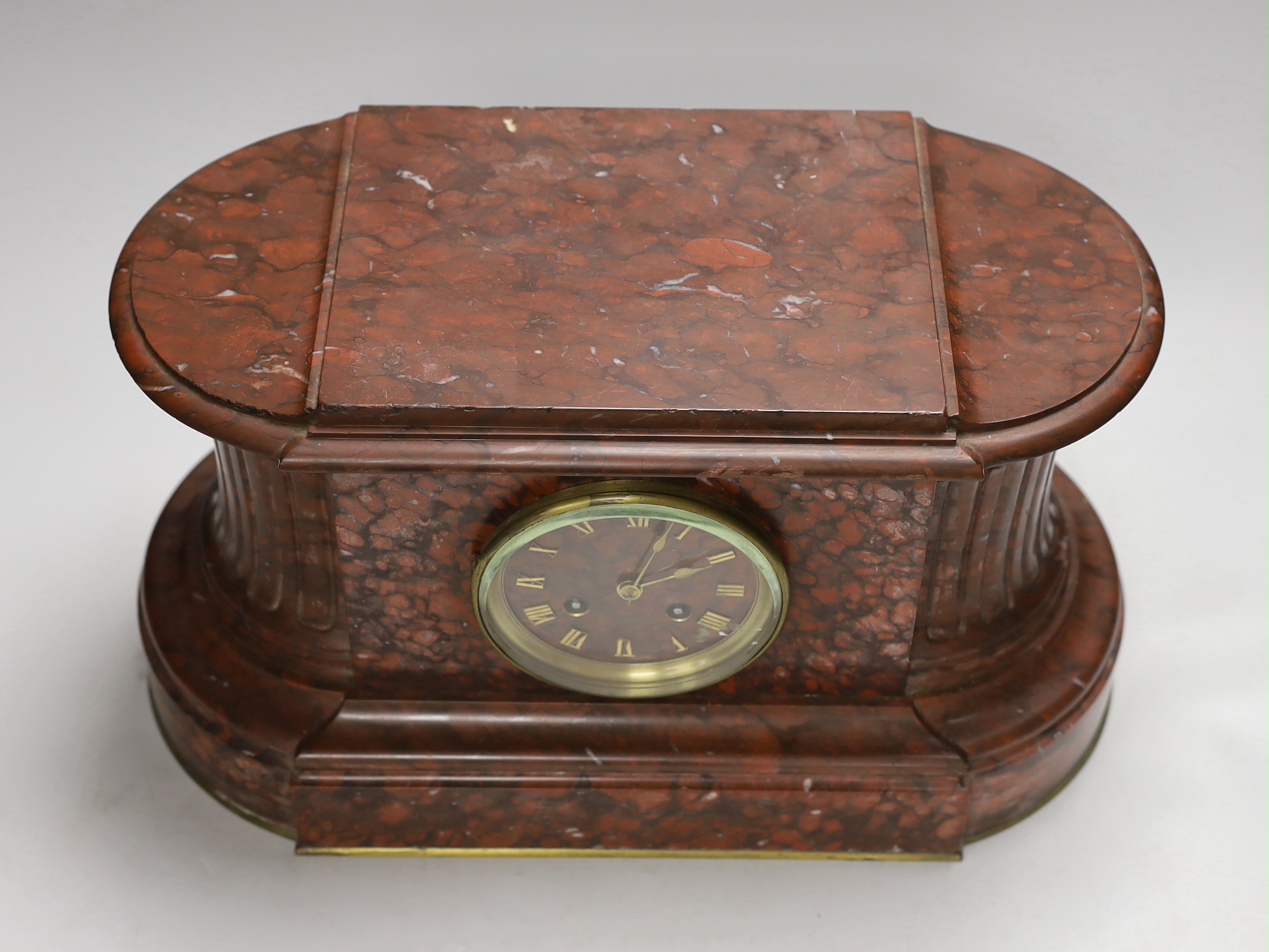 A French rouge marble eight day mantel clock, 38cm wide